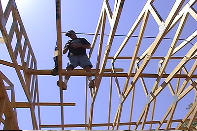 Construction worker on framed roof.