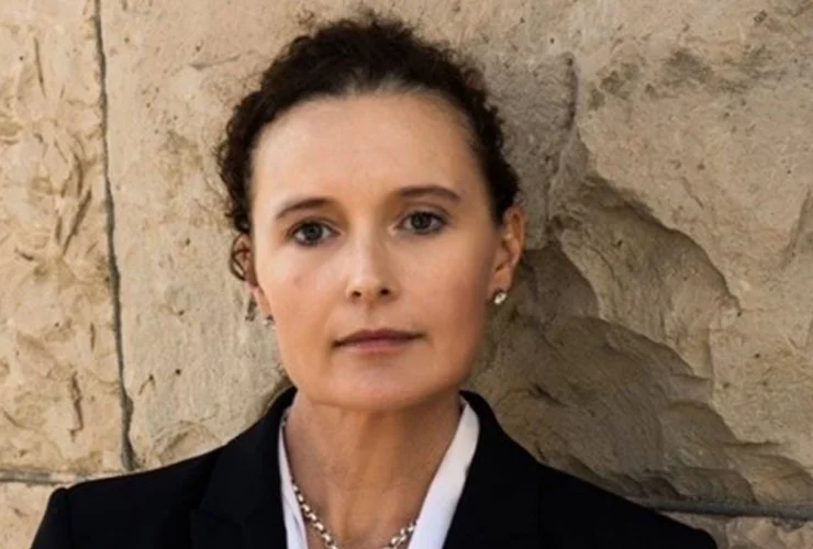 Professional woman in a black suit outside.