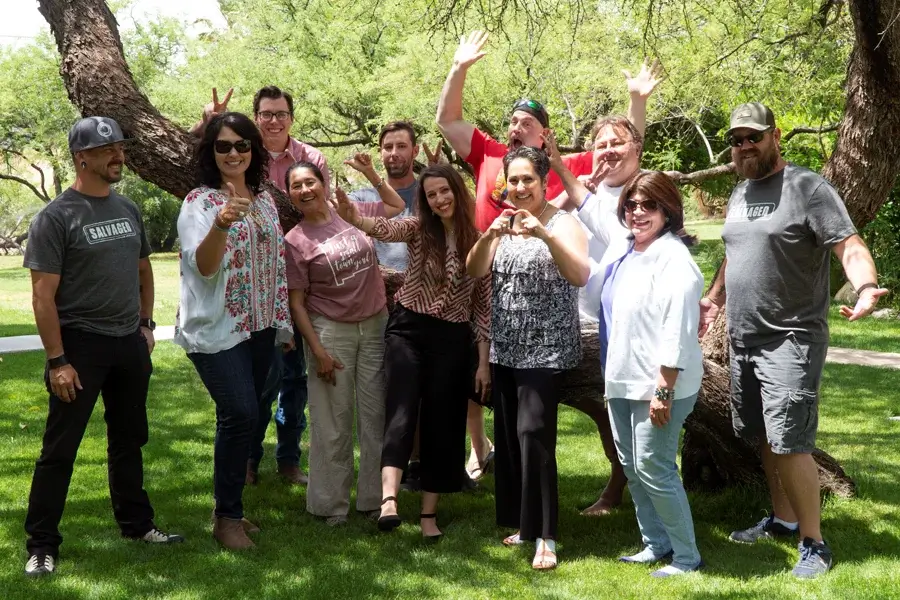 Group of people celebrating outdoors under trees