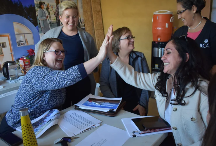 Team members celebrating success with high five